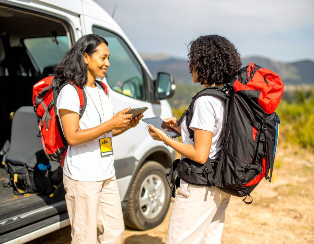 A man and a woman, aged between 30 and 40, with a smiling and professional demeanor, looking ready to assist with your BagWay Express luggage transport needs camino portugues.
